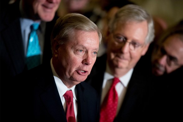 Sen. Lindsey Graham flanked by Sen. Mitch McConnell, both in black suits with red ties.