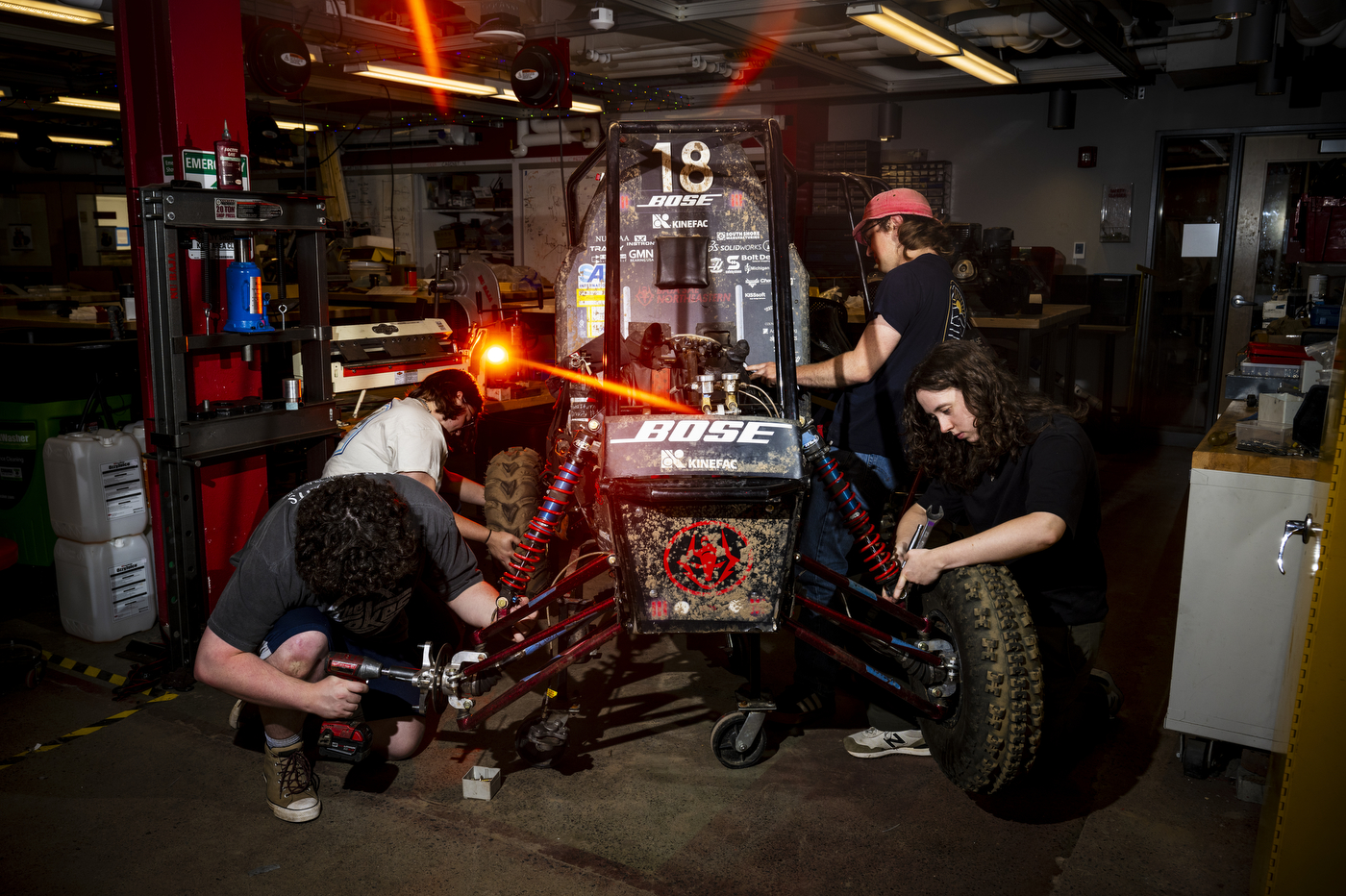 Members of the Northeastern Baja SAE club work on the off-road vehicle in the COE Makerspace in Richards Hall.