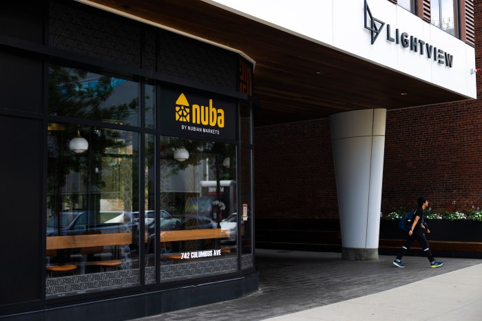 Exterior of Nuba by Nubian Markets storefront beneath the Lightview building sign, with a pedestrian walking past.