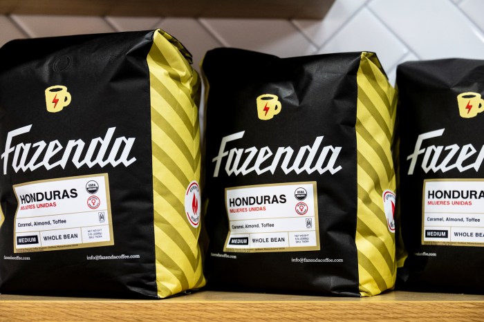 Bags of Fazenda coffee, including a Honduras variety, displayed on a shelf inside Nuba by Nubian Markets.
