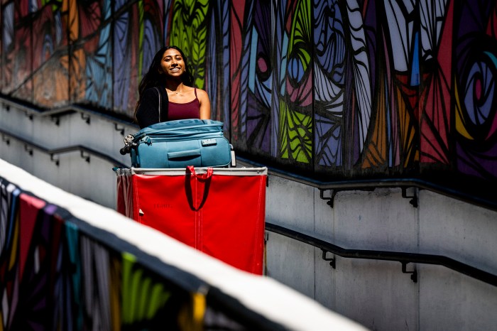 A student pushes a red move in bin down a ramp.