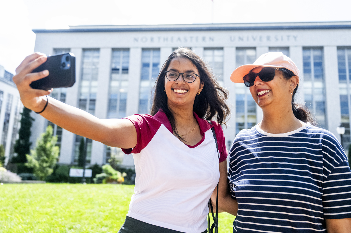 Incoming graduate student Aditi Sastry takes a selfie with her mom Rekha at Krentzman Quad, with a Northeastern building in the background.