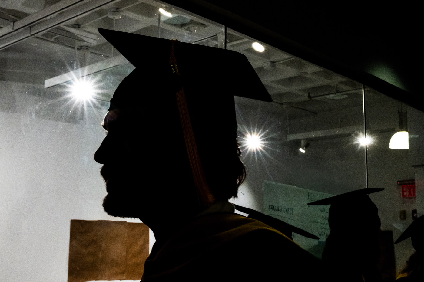 Silhouette of a graduate in a cap and gown at the Bouvé College Physician Assistant and Physical Therapy Graduation Celebration in Blackman Auditorium.