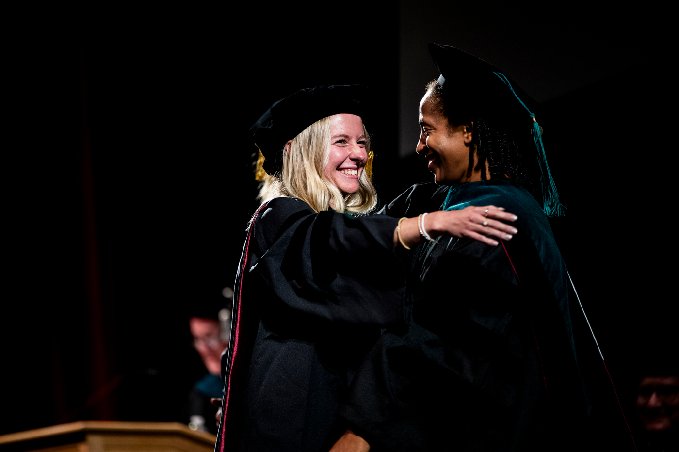 Alisha Stadnicki hugs a professor on stage at the Bouvé College Physician Assistant and Physical Therapy Graduation Celebration.