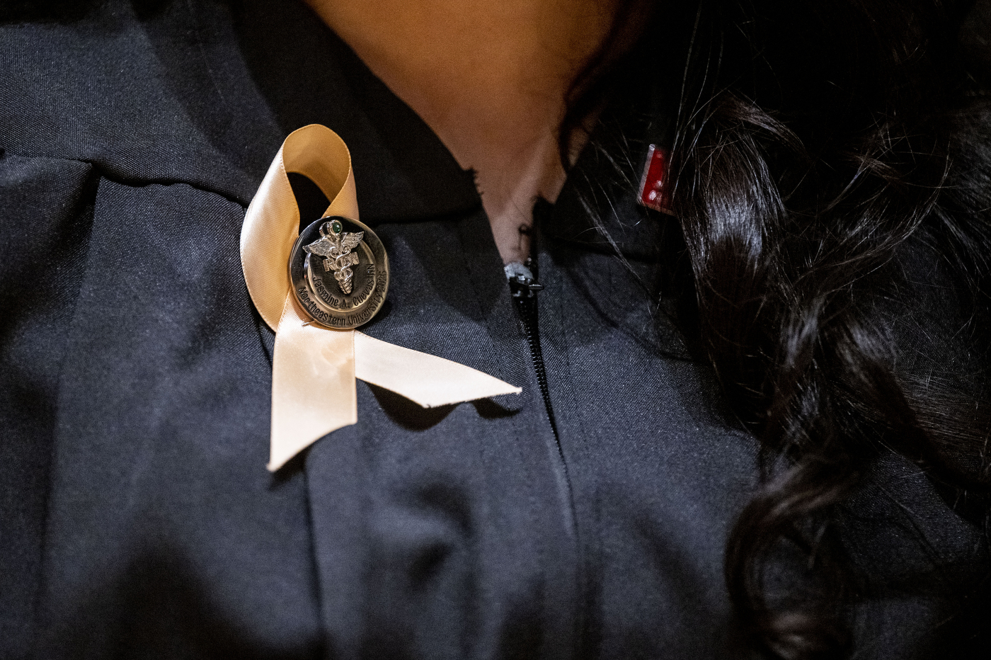 Close-up of a nursing pin attached to a ribbon on a graduate's gown during the Pinning Ceremony.