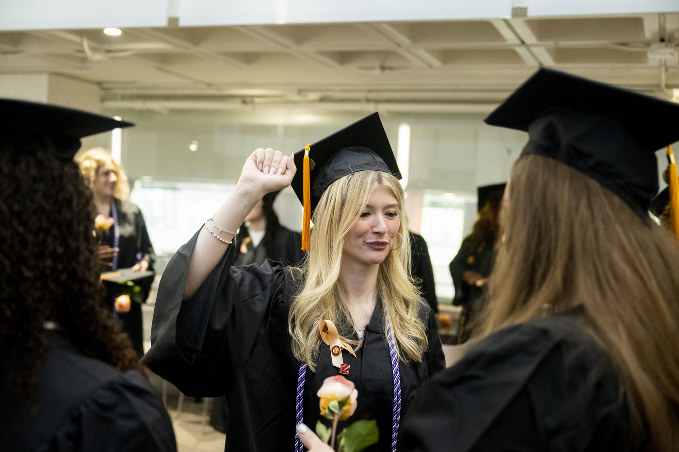 Nursing graduates in caps and gowns celebrate together during the Pinning Ceremony in Blackman Auditorium.
