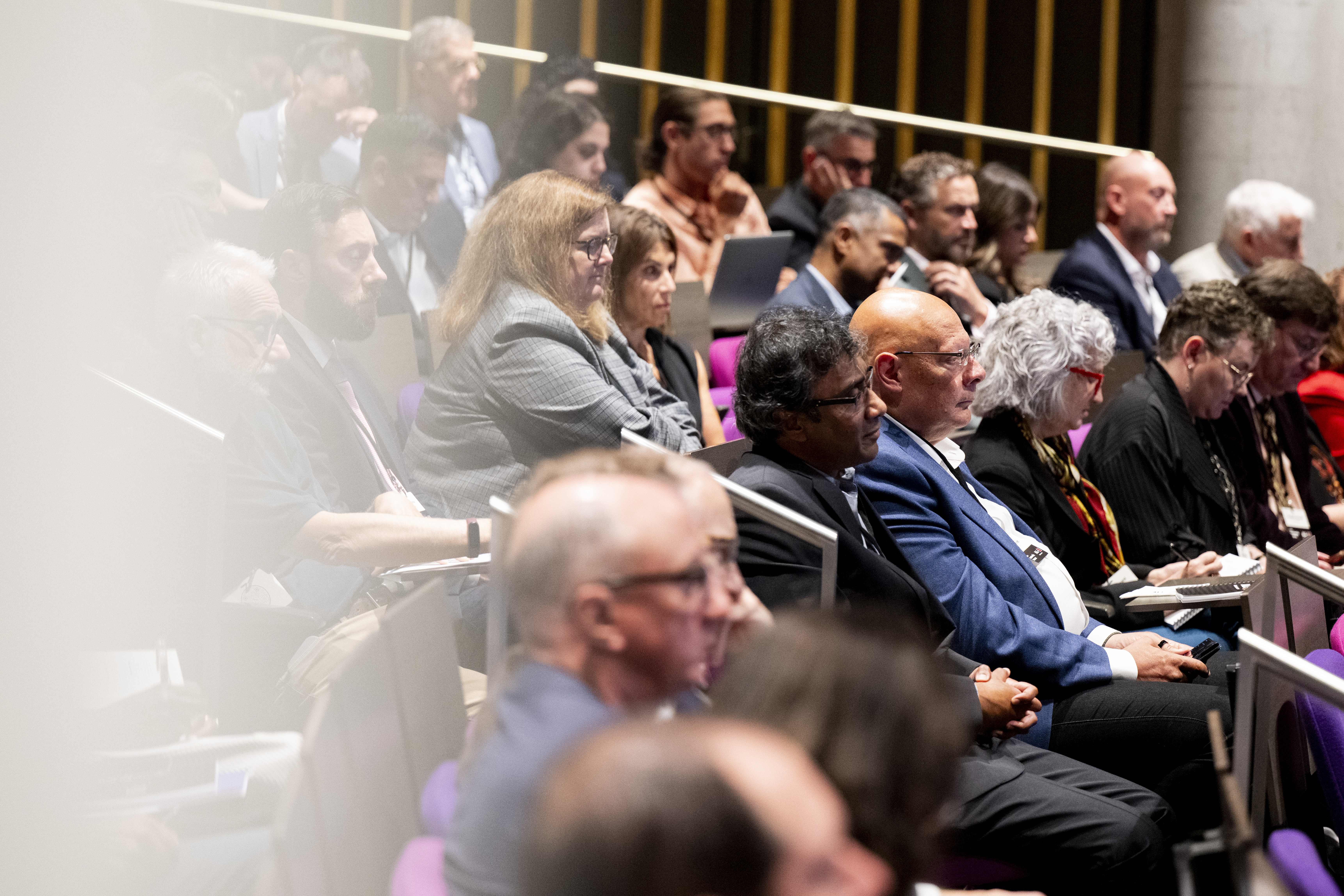 Audience members seated in tiered rows, listening attentively during the leadership retreat session.
