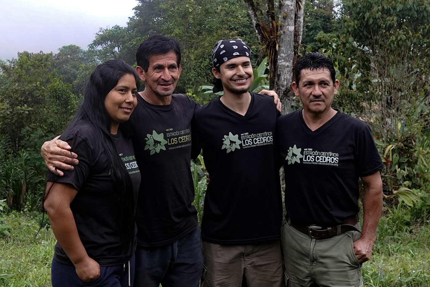 Adrian Baez and four others pose for a photo, wearing Los Cedors t-shirts while in a cloud forest.