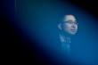Raymond Fu poses for a portrait with a deep blue background.