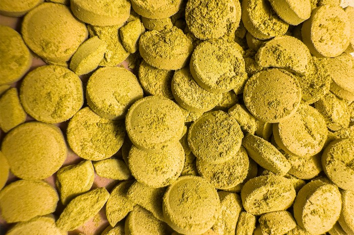 Close-up of kratom powder pressed into round tablets.