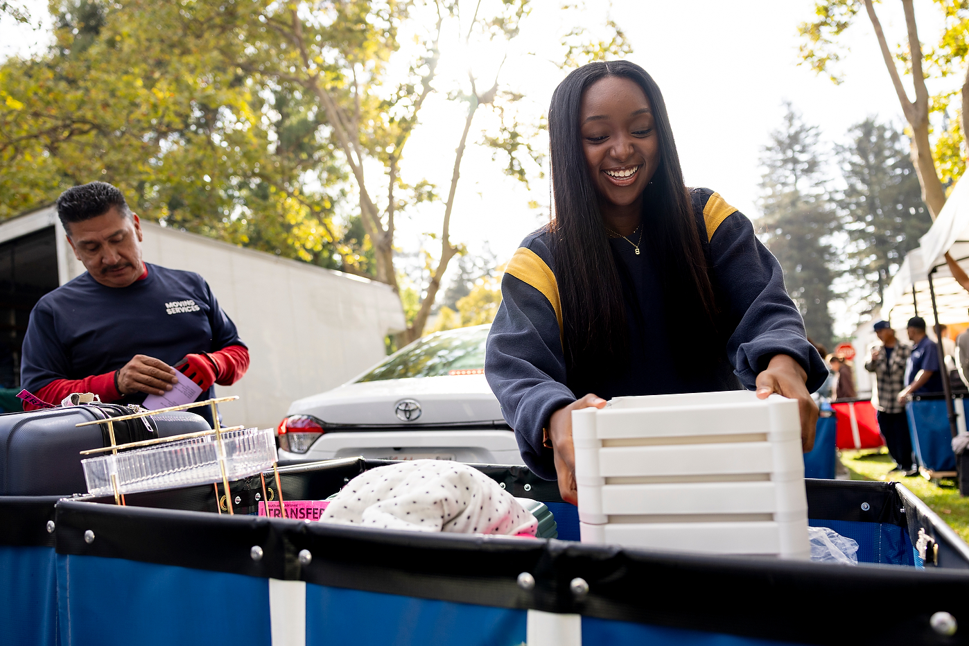 Student Breana Ballard unloads luggage from her car during Oakland move-in.