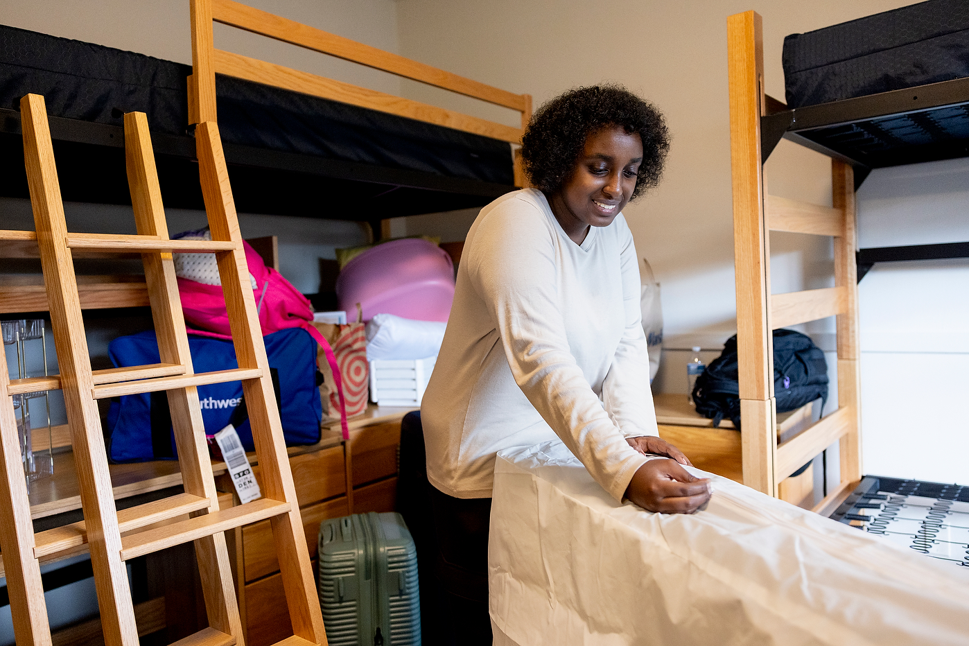 Student Azari Abdinur unpacks belongings in dorm room during Oakland move-in.