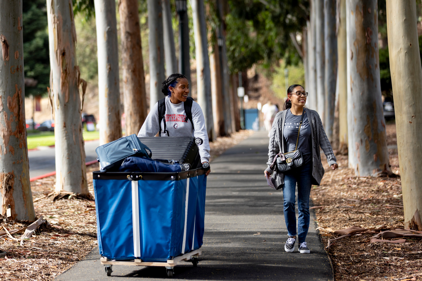 Student Katelyn Shoy pushes a bin alongside her mom during Oakland move-in.