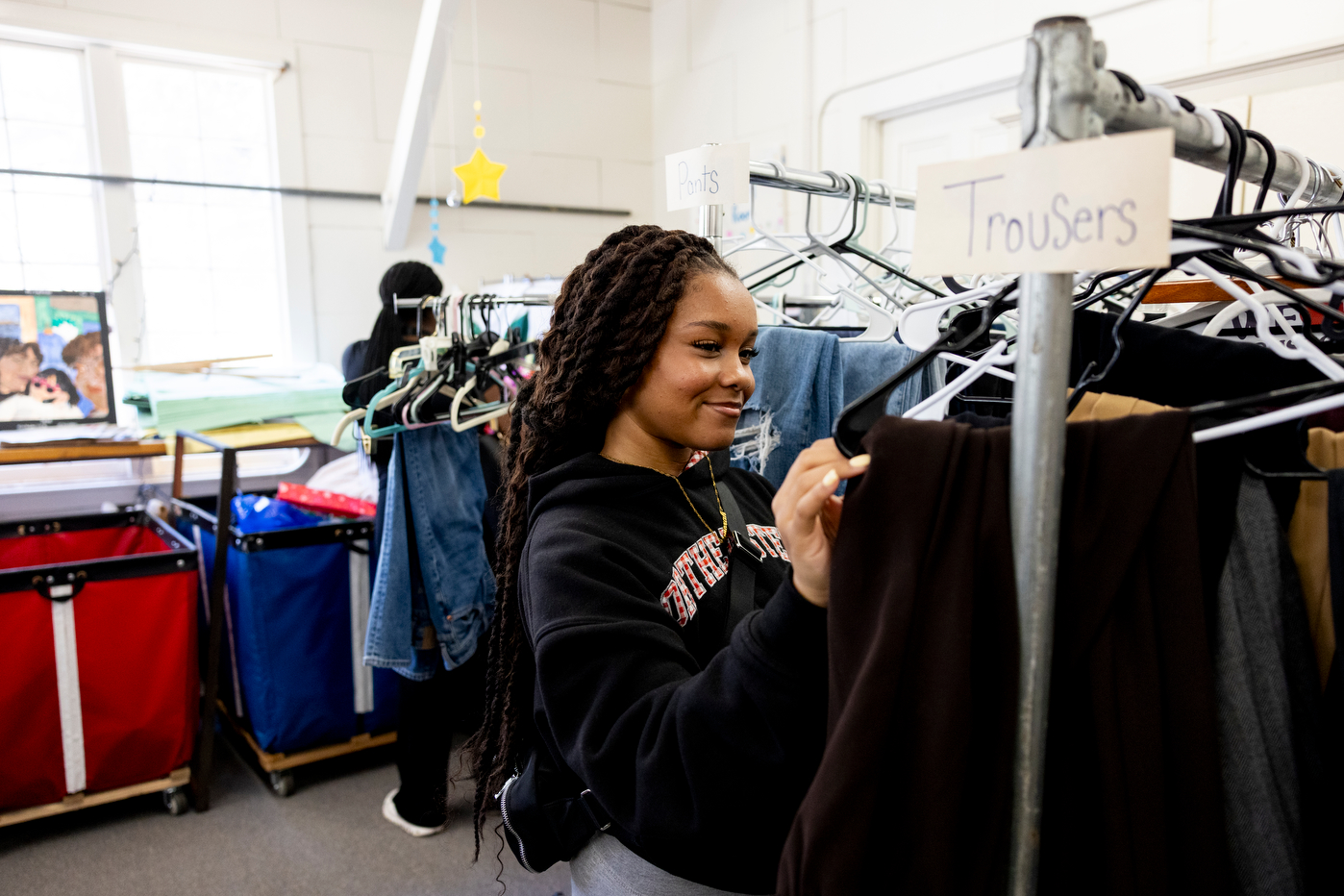 Student Menorah Hawkins browses clothing racks at the Reuse Depot.