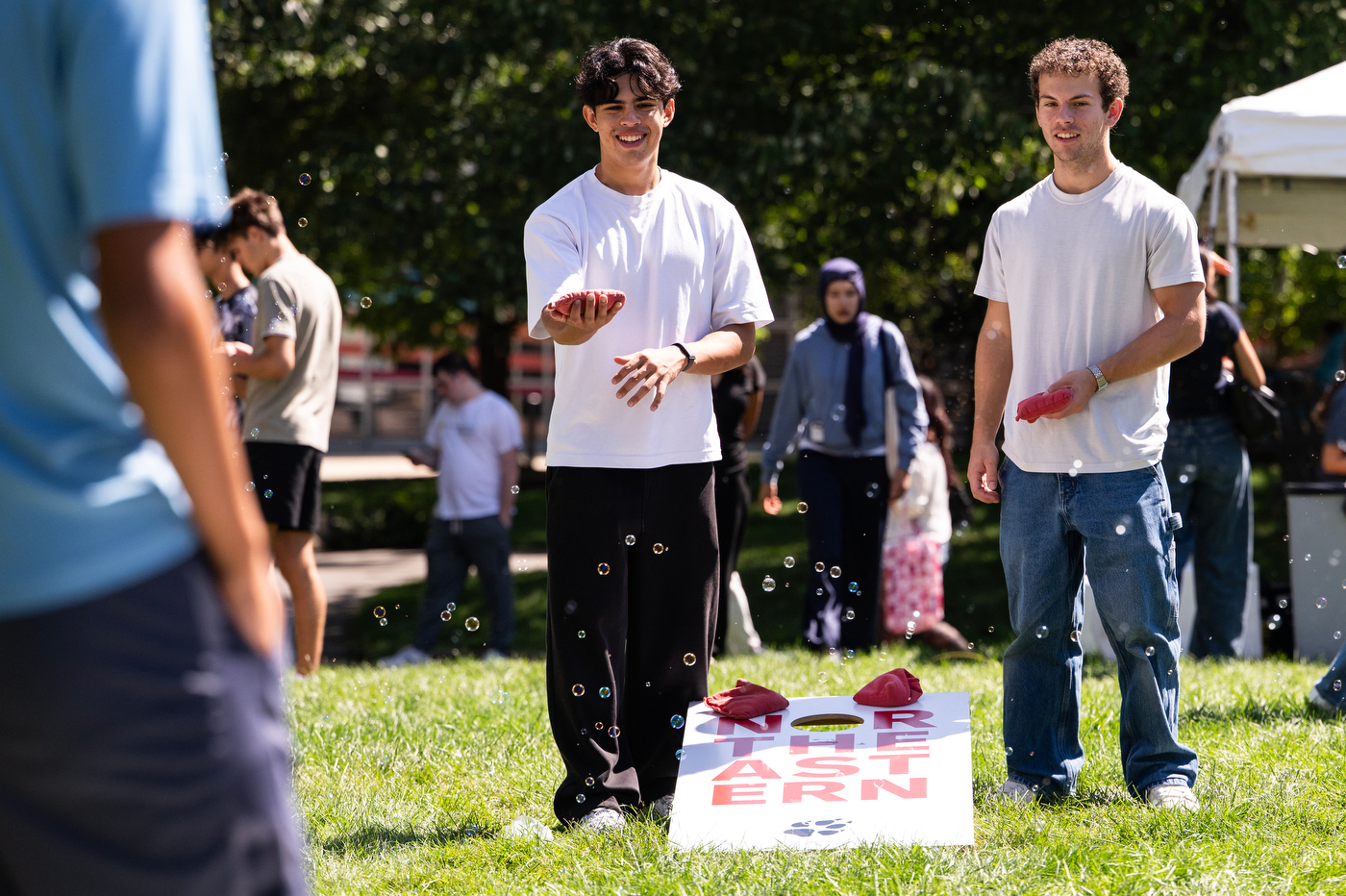 Two Northeastern students toss water balloons during the Welcome Week BBQ on Centennial Common.
