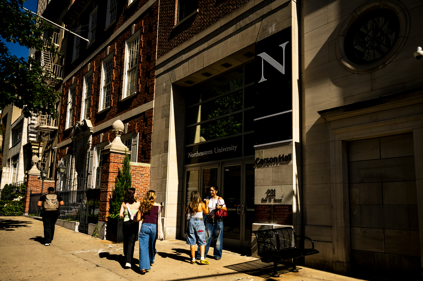 Students walking and chatting outside of the New York City campus building.