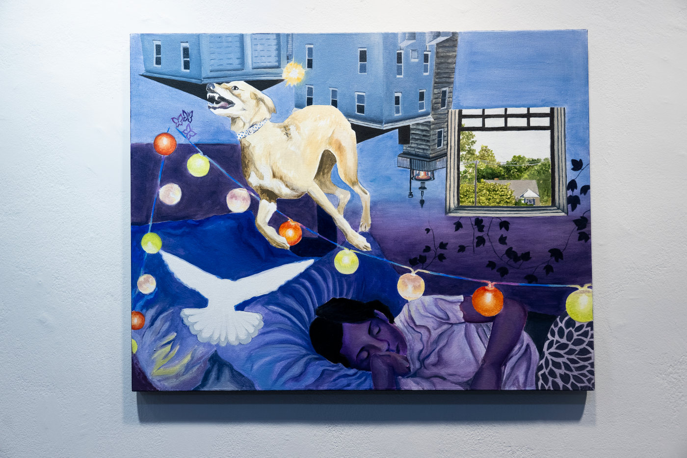 Surrealist painting of a sleeping person surrounded by a dog, white bird, suburban houses and colorful string lights in a blue and purple interior.