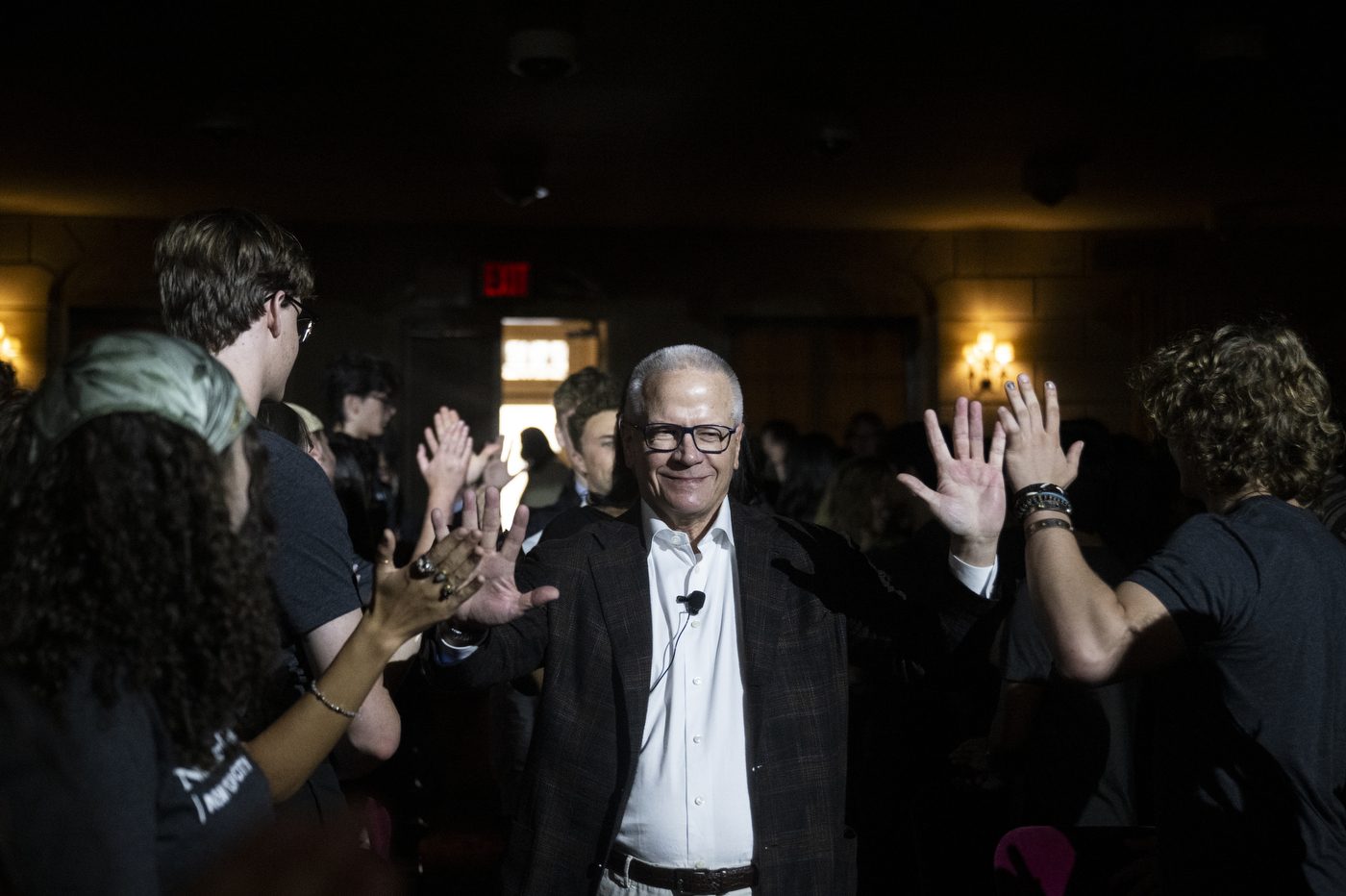 A Northeastern University administrator gives high fives to students during the New York City convocation.