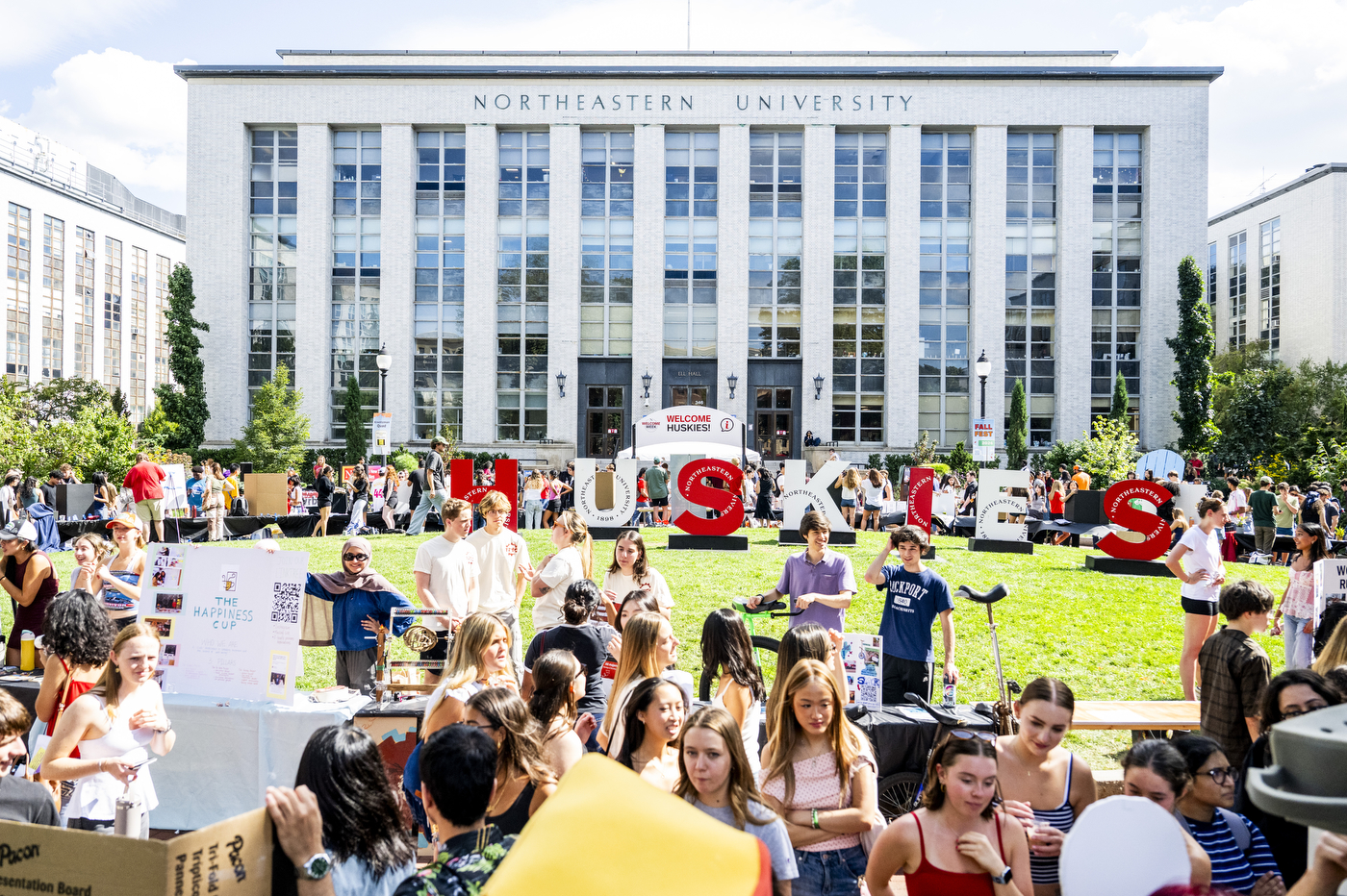 Crowd of students gathers in front of a university building.