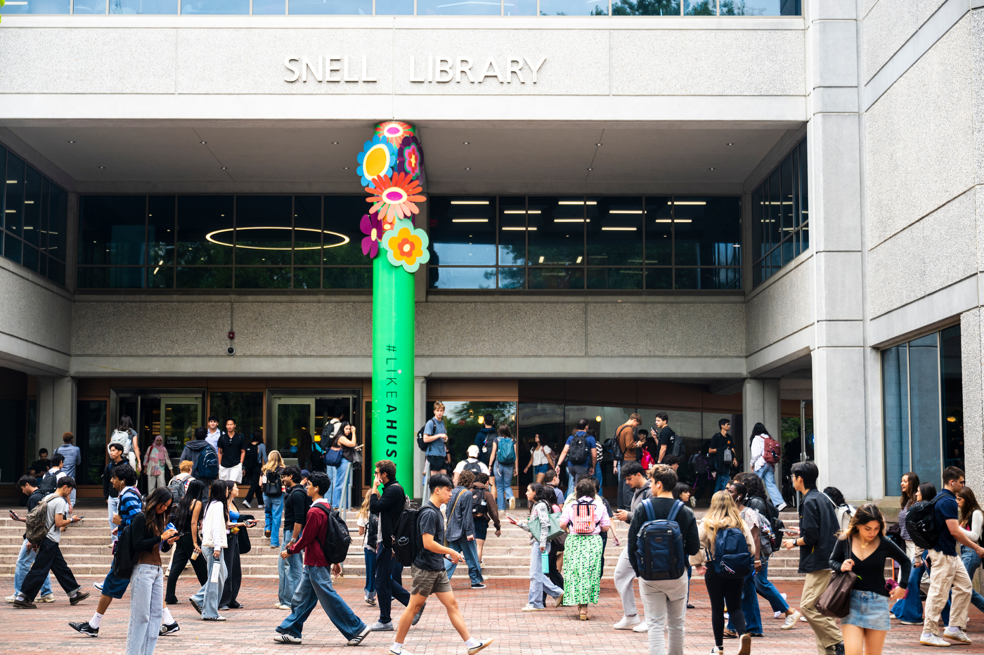 A photo of a crowd of students walking in front of Snell Library.