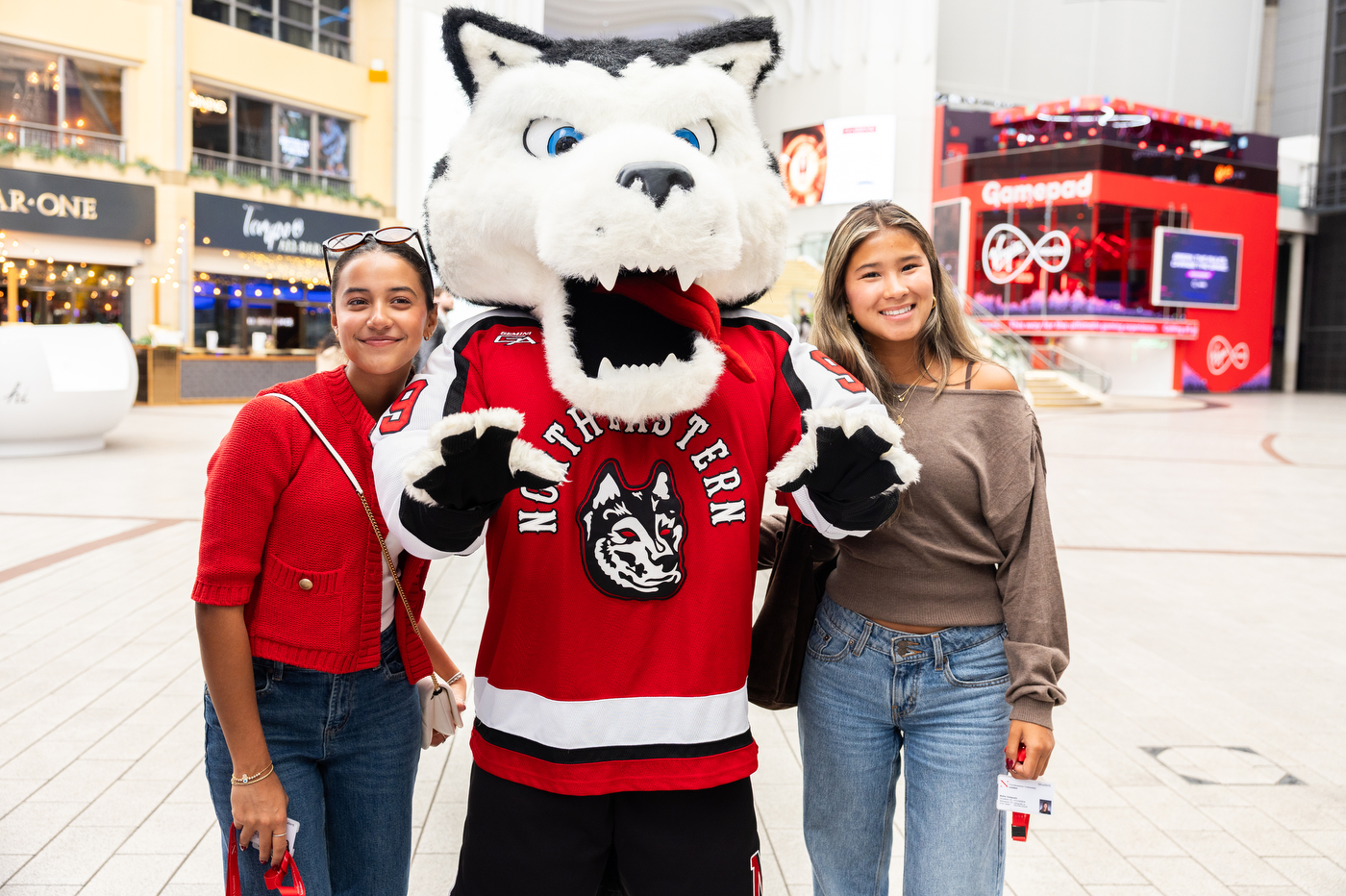 Two students pose with Paws the mascot.