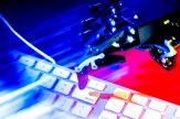 A robot hand shown hovering over a delete key on a keyboard.