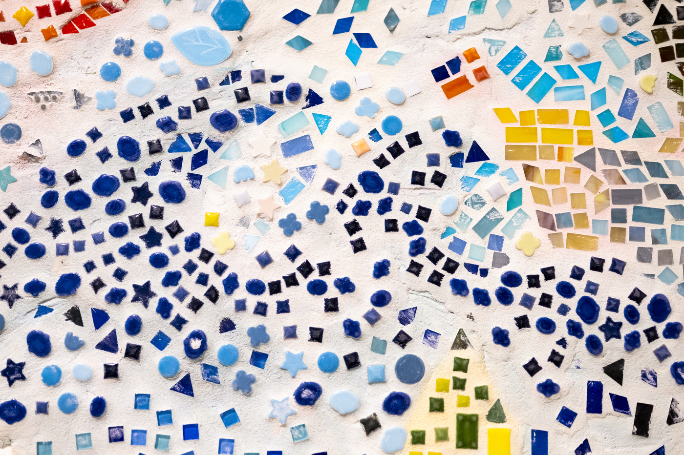 Detail of a mosaic mural featuring blue, red and yellow geometric shapes made by Boston youth for the "Can You Hear the City?" exhibit.