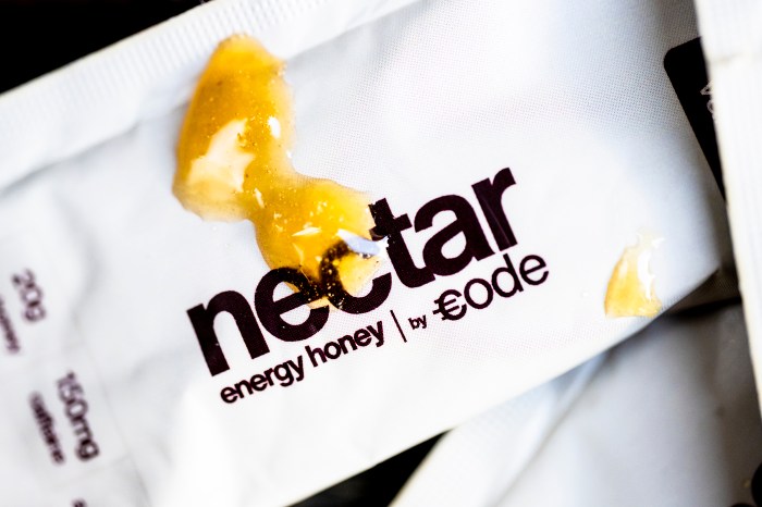Blobs of raw honey on a white Nectar energy honey sachet branded "by Code."