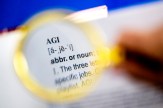 A magnifying glass held over a dictionary entry for "AGI."