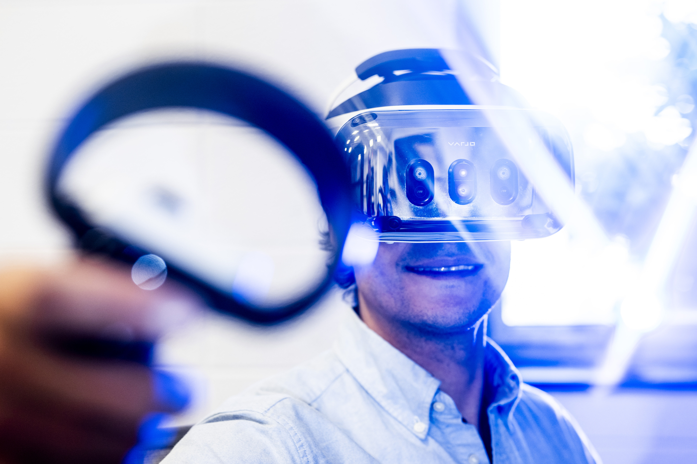 Quentin Coppola wearing a virtual reality headset and holding a hand controller which is blurred in the foreground. 